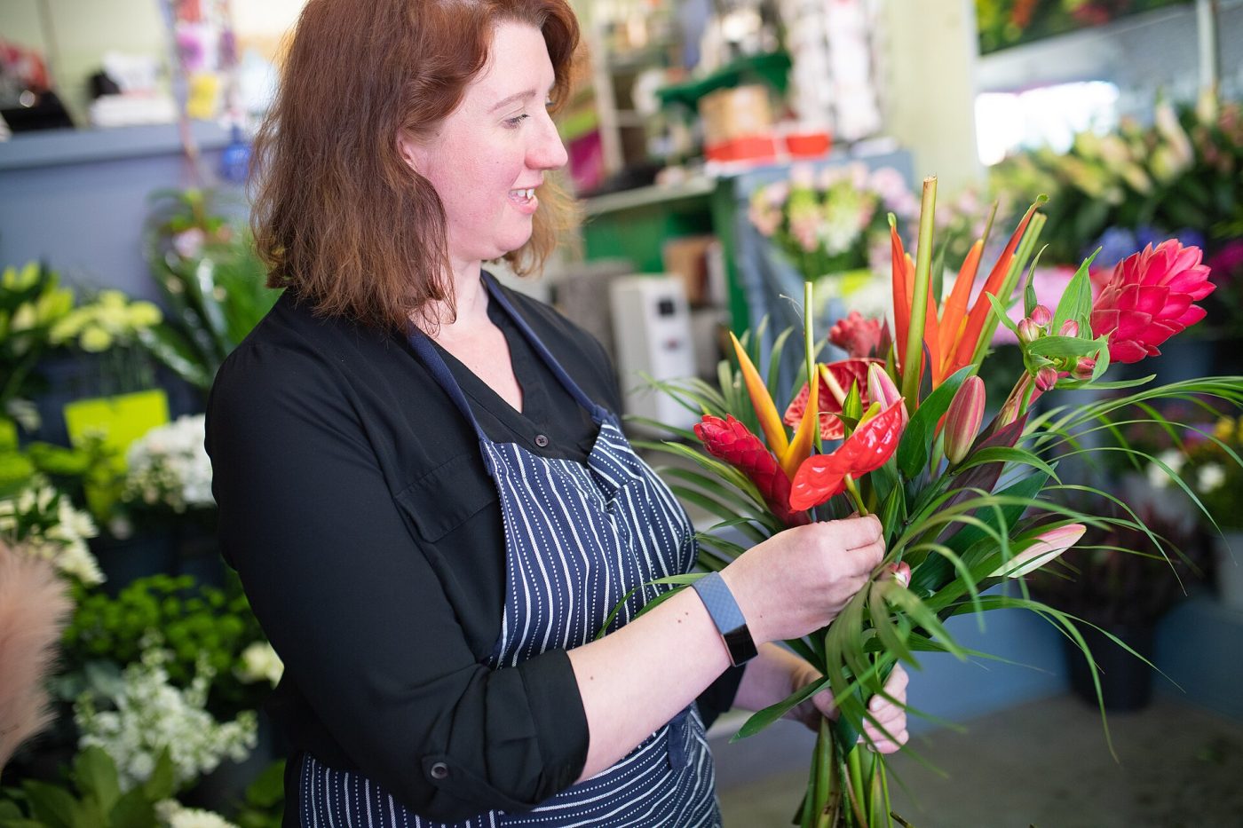 A florist carefully arranging a bouquet by hand